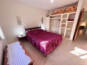 a bedroom with a bed and a bench in it at Hermosa y amplia casa con pileta in San Antonio de Arredondo +16 photos