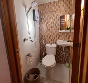 a small bathroom with a toilet and a sink at JMCL RESIDENCES in Tacloban