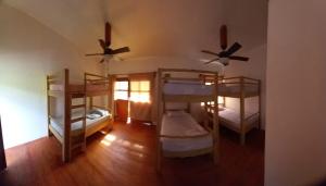 a room with three bunk beds and two fans at TOnat Caribe Hostel01 in West End
