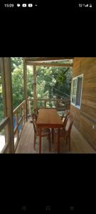 una mesa de madera y sillas en el porche de una cabaña en TOnat Caribe Hostel01, en West End