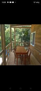 a wooden table and chairs on the porch of a cabin at TOnat Caribe Hostel01 in West End