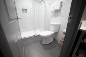 Un baño blanco con ducha y WC. en Palms Motel, en Pico Rivera