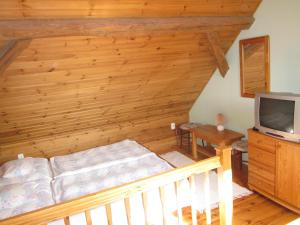 a bedroom with a bed and a tv in a room at Bozsoki Pihenő in Bozsok