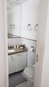 Baño blanco con aseo y lavamanos en Apartamento Frente Lagoa - RJ en Río de Janeiro