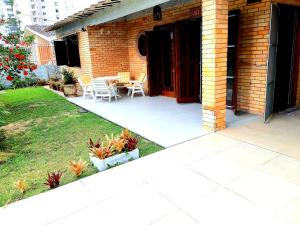 um pátio com mesa e cadeiras em um quintal em Casa ÍSIS de aluguel por temporada em Capão da Canoa com piscina em Capão da Canoa
