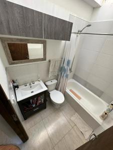 a bathroom with a sink and a toilet and a tub at Villa Gesell- Av.27 e/100 y 101 in Villa Gesell
