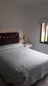 a bedroom with a bed with a blanket and a window at Villa Gesell- Av.27 e/100 y 101 in Villa Gesell