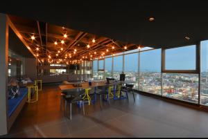 a dining room with a view of a city at The Base Central Pattaya in Pattaya Central