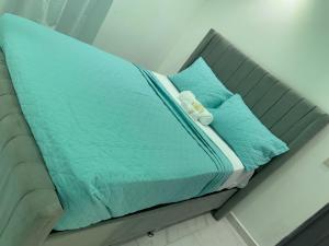 1 cama con edredón azul y 2 almohadas en HOTEL LUXURY V.I.P, en Estero Hondo