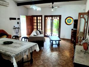 a living room with a couch and a table at Casa ÍSIS de aluguel por temporada em Capão da Canoa com piscina in Capão da Canoa