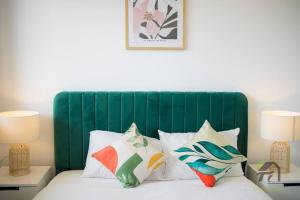 a bed with a green headboard and pillows on it at Entire apartment in Arncliffe in Sydney