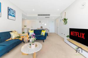 a living room with a blue couch and a table at Entire apartment in Arncliffe in Sydney