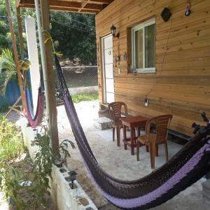a hammock outside of a house with a table and chairs at TOnat Caribe Hostel01 in West End
