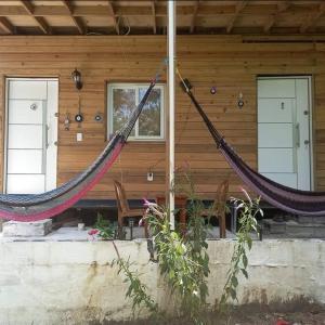 a couple of hammocks in front of a log cabin at TOnat Caribe Hostel01 in West End