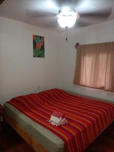 a bedroom with a bed with a red striped blanket at TOnat Caribe Hostel01 in West End
