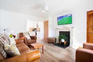 a living room with a couch and a fireplace at Mike's 3-bedroom Countryside Cottage in Alness