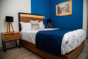 a bedroom with a large bed with a blue wall at Quinta Mercedes in Guanajuato
