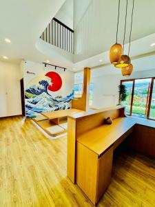 a living room with a wooden table with a wave mural at Nathy Villa in Khu Chi Lăng