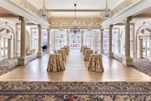 a ballroom with tables and chairs in a room with large windows at The Omni Homestead Resort & Spa in Hot Springs +213 photos