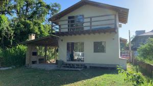 una casa con balcone in cima a un cortile di Toca do Siri a Imbituba