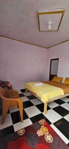 een slaapkamer met 2 bedden en een geruite vloer bij Anadas Garden & Glamping in Pagaralam