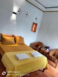 een slaapkamer met een bed met twee handdoeken erop bij Anadas Garden & Glamping in Pagaralam