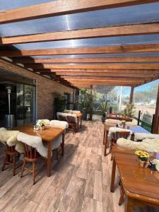 a restaurant with wooden tables and chairs on a patio at Pousada Le Sorelle ap04 in Rosário do Sul