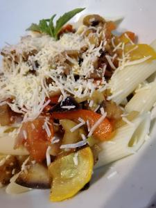 a plate of pasta with cheese and vegetables at Santuario Tayrona Hostel in Calabazo