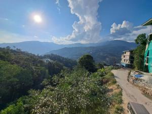 uma estrada de terra com montanhas ao fundo em Snow White Retreat Hotel and Restaurant em Gangtok