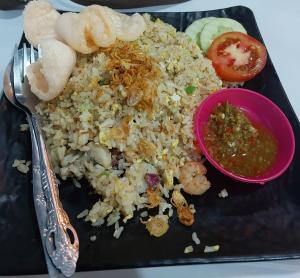 a plate of food with rice and shrimp and a sauce at Anadas Garden & Glamping in Pagaralam