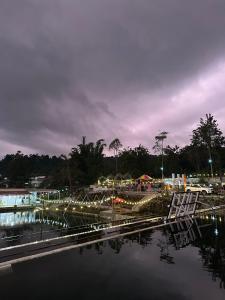 a bridge over a body of water at night at Anadas Garden & Glamping in Pagaralam +6 photos