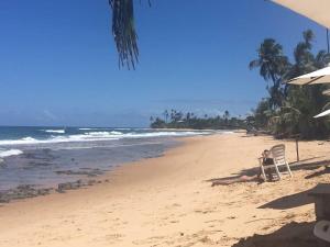 a person sitting on a chair on a beach at Suite 1 in Marau