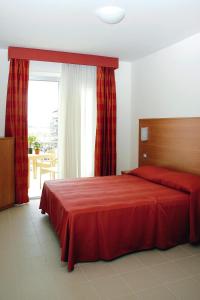 um quarto com uma cama vermelha e uma janela em Apartment in Roseto Degli Abruzzi em Roseto degli Abruzzi