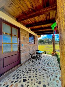 a porch of a house with a table and a door at Cabañas el Corral del Rayo Huasca in Huasca de Ocampo