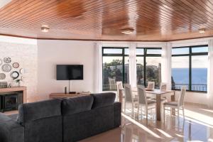 a living room with a couch and a table with chairs at Casa Coelho in Ponta do Sol