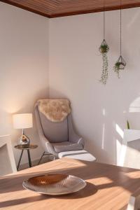 a living room with a chair and a table at Casa Coelho in Ponta do Sol