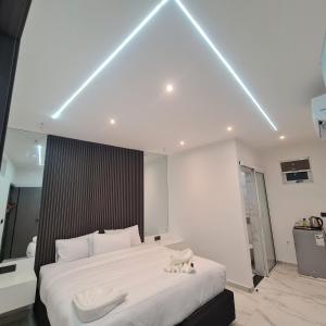 um quarto com uma cama grande e lençóis brancos em White Garden Hotel em Maputo