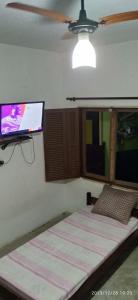 - une chambre avec un lit et une télévision murale à écran plat dans l'établissement Casa prática e completa próxima de tudo, à Ubatuba