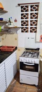 a kitchen with a stove top oven in a kitchen at Casa prática e completa próxima de tudo in Ubatuba