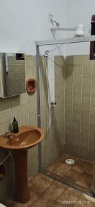 a bathroom with a shower with a wooden sink at Casa prática e completa próxima de tudo in Ubatuba