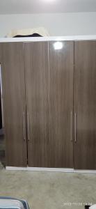 a pair of wooden cabinets in a room at Casa prática e completa próxima de tudo in Ubatuba