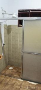 a shower with a glass door in a bathroom at Casa prática e completa próxima de tudo in Ubatuba