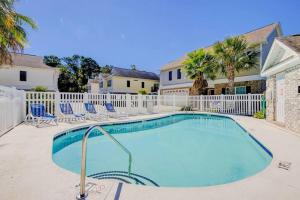 a swimming pool with chairs and a fence at Spacious House with Pool near the Beach 2165 in Myrtle Beach