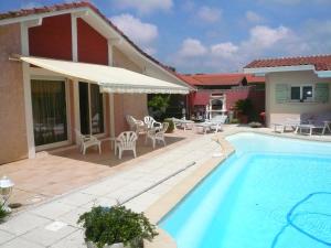 uma piscina com um pátio e uma casa em Maison Tarnos, 4 pièces, 6 personnes - FR-1-239-779 em Tarnos