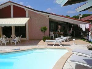 uma villa com uma piscina e uma casa em Maison Tarnos, 4 pièces, 6 personnes - FR-1-239-779 em Tarnos