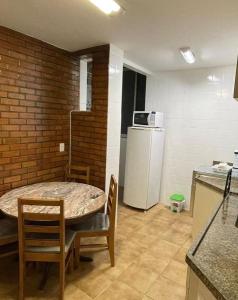 a kitchen with a table and chairs and a refrigerator at Copacabana, confortável apto de 2 quartos, quadra da praia in Rio de Janeiro