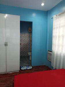 uma casa de banho com um WC e uma parede azul em Josephine's Home Donsol Sorsogon em Donsol