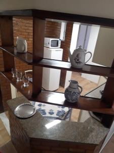 a shelf with a tea pot and a microwave at Copacabana, confortável apto de 2 quartos, quadra da praia in Rio de Janeiro