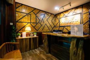 a bar in a restaurant with a stone wall at Anggun Hotel in Seri Iskandar
