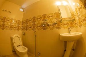 a bathroom with a sink and a toilet and a mirror at Subedi Apartment in Pokhara